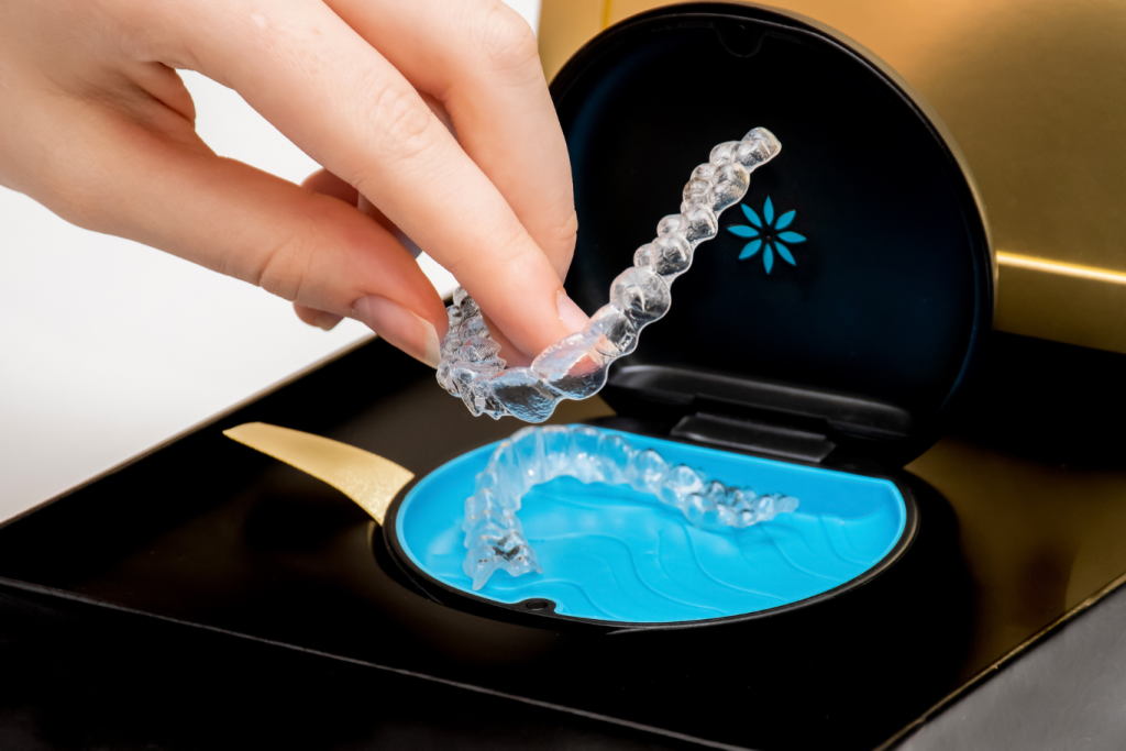 A young woman’s hand placing an Invisalign aligner into its case.