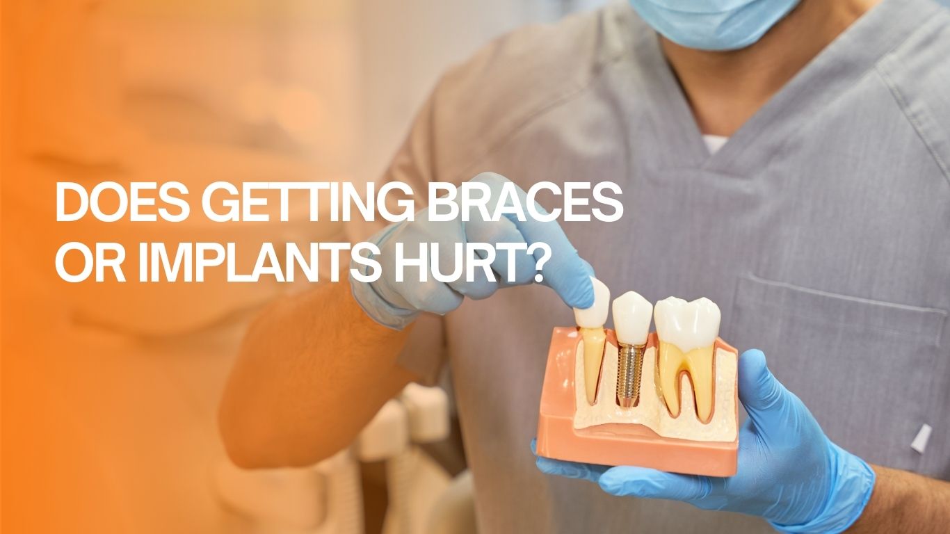 A dental professional wearing holds a model of teeth and points to a dental implant